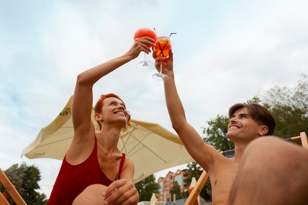 Photo portrait d'homme et de femme en été avec une esthétique et des cocktails des années 80