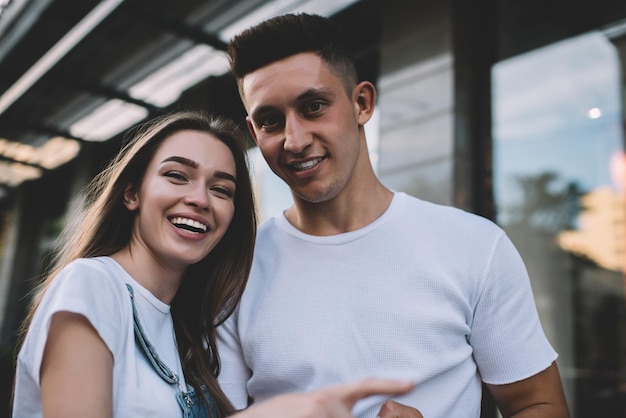 portrait d'un homme et d'une femme joyeux debout dans un cadre urbain et riant pendant le temps libre