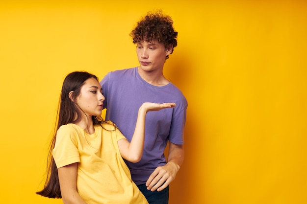 Portrait d'un homme et d'une femme en t-shirts colorés posant amitié amusant fond jaune inchangé