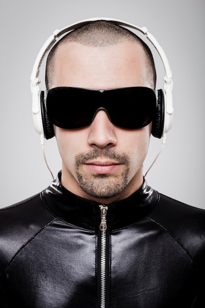 Portrait d'homme futuriste écoutant de la musique avec des écouteurs sur fond blanc