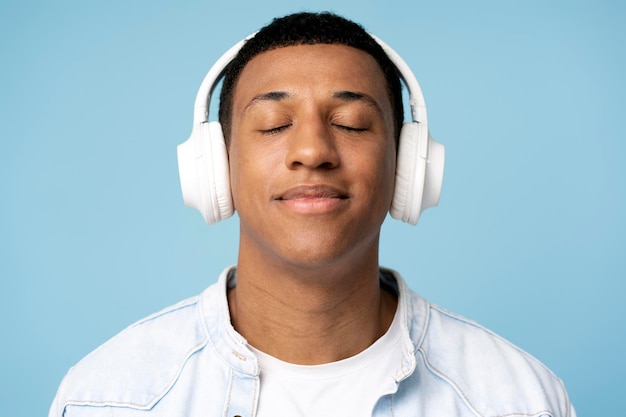 Portrait d'un homme gai portant des écouteurs écoutant de la musique préférée