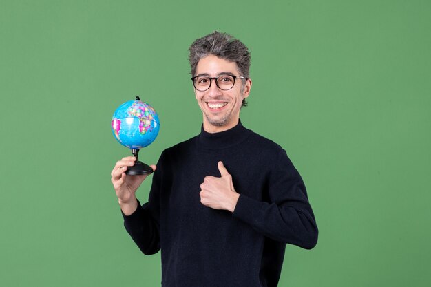 Portrait d'un homme de génie tenant un globe terrestre tourné en studio fond vert école air mer espace nature planète