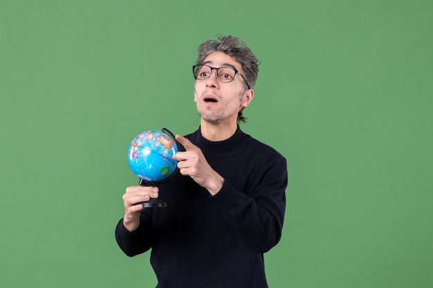 Portrait d'un homme de génie tenant un globe terrestre tourné en studio fond vert enseignant mer espace nature planète air