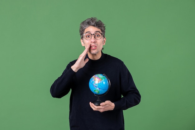 Portrait d'un homme de génie tenant un globe terrestre tourné en studio fond vert nature professeur planète mer espace