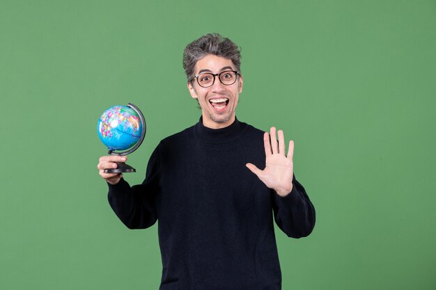 Portrait d'un homme de génie tenant un globe terrestre tourné en studio fond vert professeur d'espace planète nature air