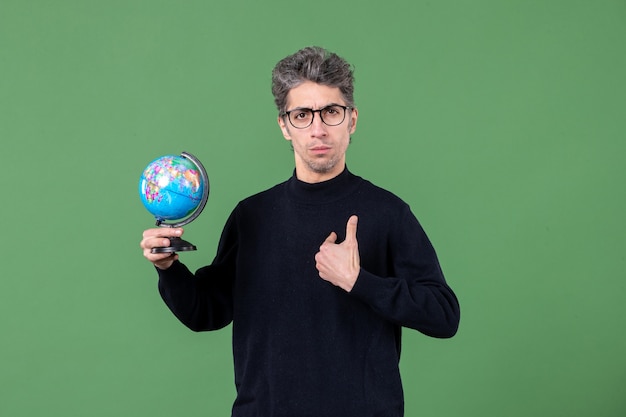 Portrait d'un homme de génie tenant un globe terrestre tourné en studio fond vert professeur d'espace planète nature mer