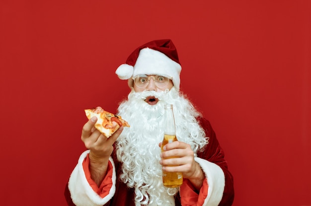 Portrait homme habillé en père Noël tenant la pizza et la bière