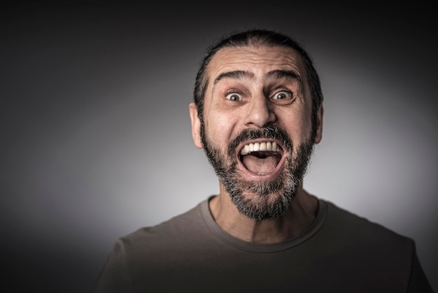 Portrait d'un homme heureux criant sur un fond gris