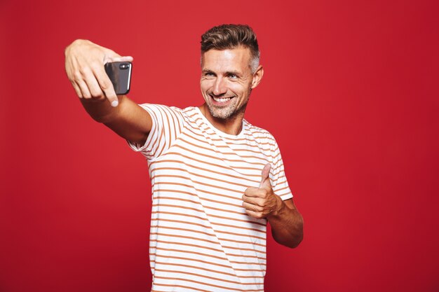 Portrait d'un homme heureux debout sur le rouge