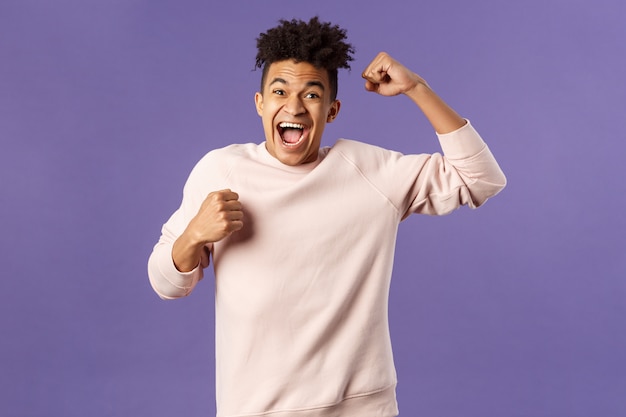 Portrait D'un Homme Heureux Excité En Voyant Son équipe Marquer Un But Sur La Chaîne De Télévision Sportive, En Chantant Une Main En Triomphe, En Criant De Joie Et De Bonheur, En Célébrant La Victoire, Placé Le Bon Pari