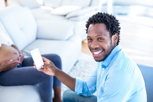 Portrait d&#39;un homme heureux maintenant smartphone