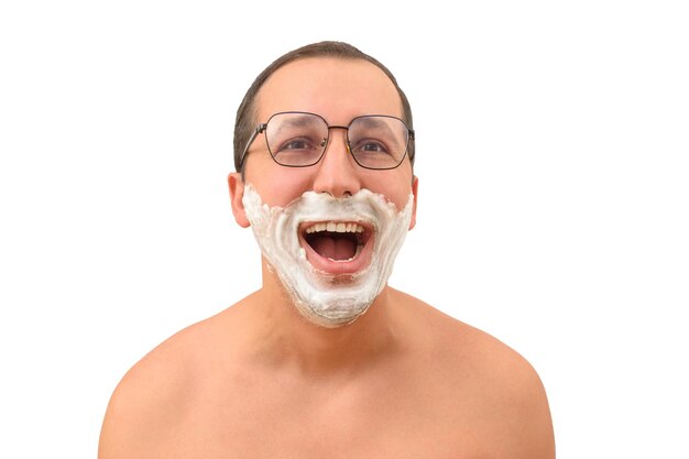 Portrait d'un homme heureux avec de la mousse à raser sur son visage sur un fond blanc isolé