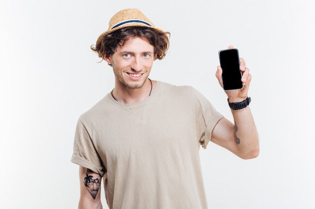 Portrait d'un homme heureux présentant un smartphone avec écran blanc isolé sur fond blanc