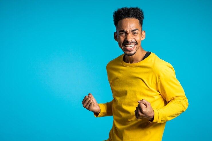 Photo portrait d'un homme heureux serrant le poing sur un fond bleu