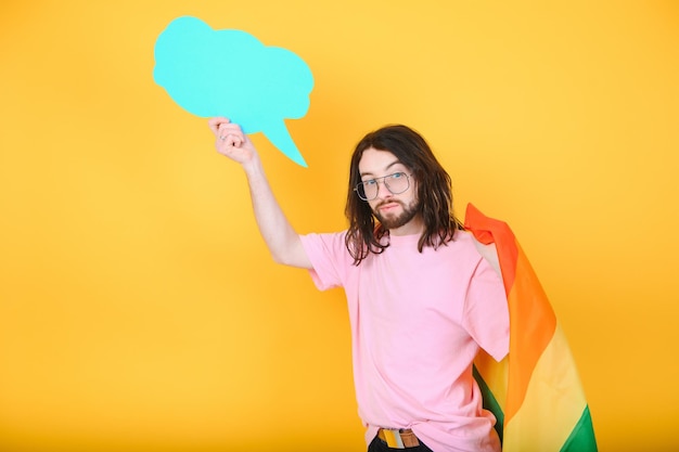 Portrait d'un homme homosexuel souriant et joyeux tenant un tableau blanc vide avec un drapeau de la fierté gay au studio drapeau Lgbtq drapeau arc-en-ciel célébrant le défilé