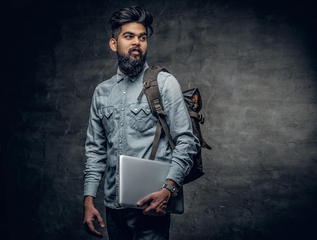 Portrait d'homme indien barbu est titulaire d'un ordinateur portable.