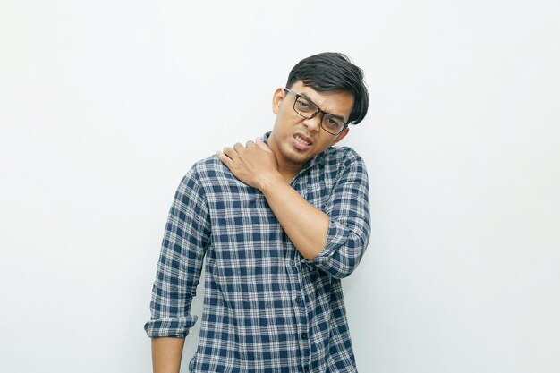 Portrait d'un homme indonésien asiatique mettant ses mains sur le cou pour ressentir la douleur geste fond blanc isolé