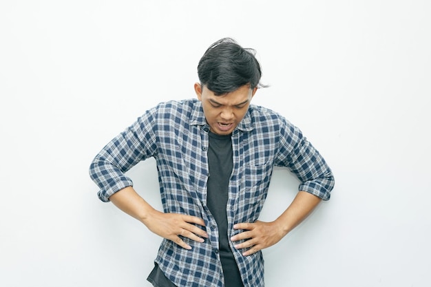 Portrait d'un homme indonésien asiatique mettant ses mains sur l'estomac pour un mal d'estomac ou un geste de faim