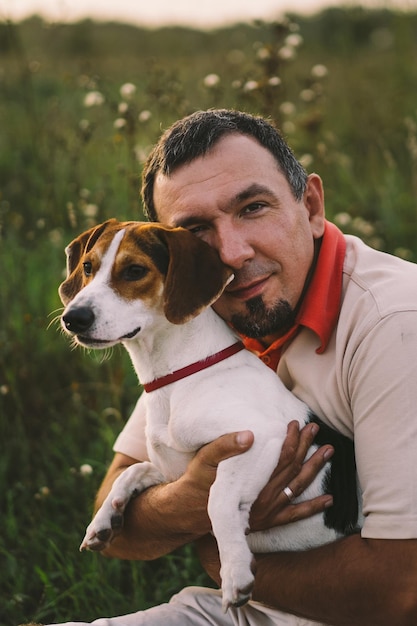 Portrait d'un homme jouant avec son chien Jack Russell dans le parc Concept d'animaux amitié gens et amour Un homme joue avec un Jack Russell terrier