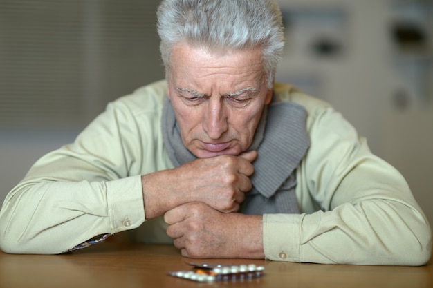 Portrait d'un homme malade âgé avec des pilules