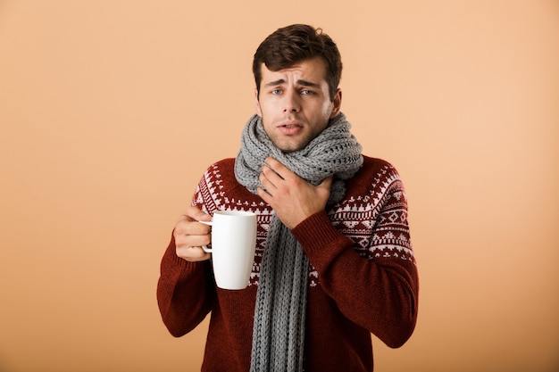 Photo portrait d'un homme malade habillé en pull et écharpe