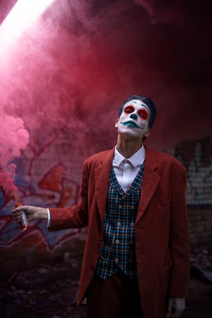 Photo portrait d'un homme avec un maquillage de clown effrayant et une lumière au néon