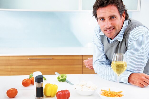 Portrait d'un homme mûr confiant debout dans la cuisine