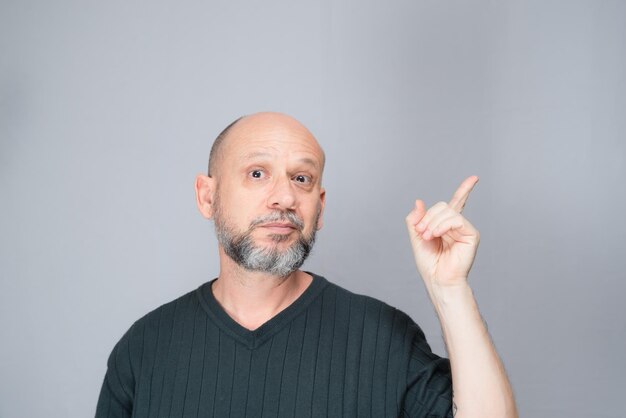 Portrait d'un homme mûr debout sur fond blanc Homme barbu chauve faisant des gestes Style formel