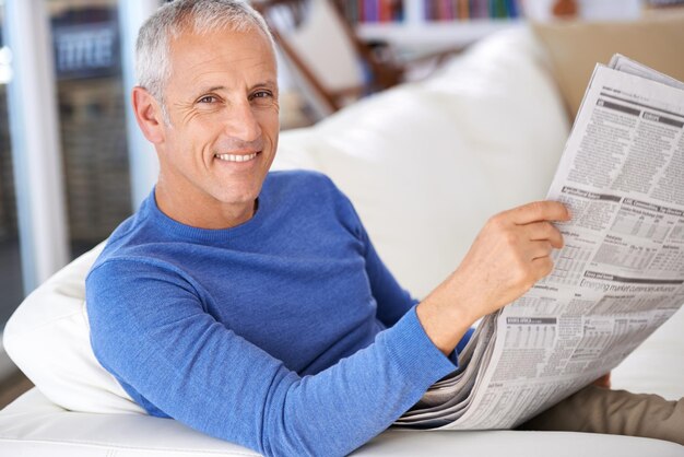 Portrait d'un homme mûr heureux lisant le journal