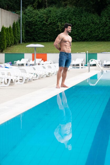 Portrait d'un homme musclé à la piscine