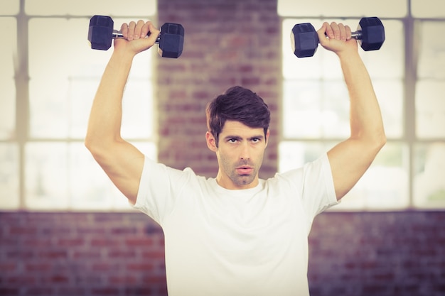 Portrait d&#39;un homme musclé soulevant des haltères