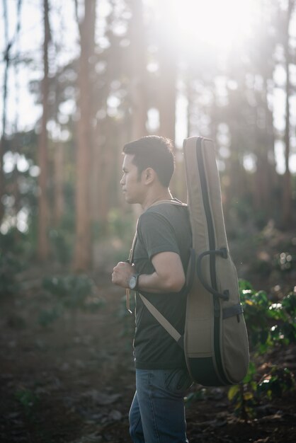 Portrait homme musicien avec guitare à la forêt