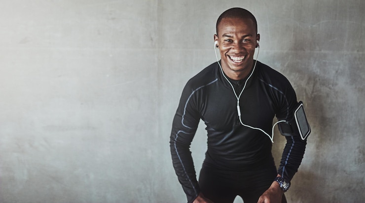Photo portrait d'homme et musique pour le fitness en plein air avec écoute de podcast ou exercice pour un corps en bonne santé avec maquette athlète personne africaine ou écouteurs avec poche de bras pour téléphone radio ou heureux pour l'entraînement