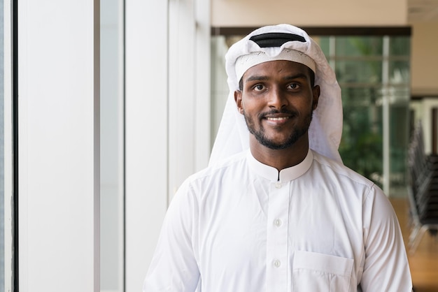 Portrait d'homme musulman africain portant des vêtements religieux une écharpe au bureau