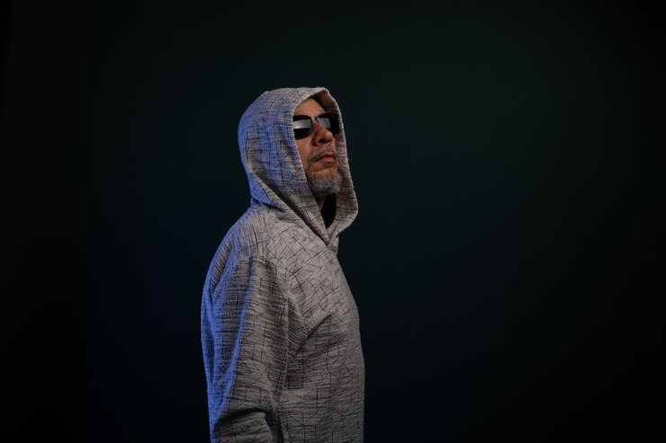 Photo portrait d'un homme mystérieux portant un sweat-shirt à capuche debout en silence
