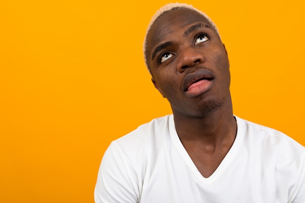 Portrait d'un homme noir africain à la mécontentement sur jaune avec copie espace