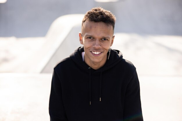 Portrait d'un homme noir aux cheveux noirs et aux yeux regardant vers l'avant avec un visage souriant et heureux