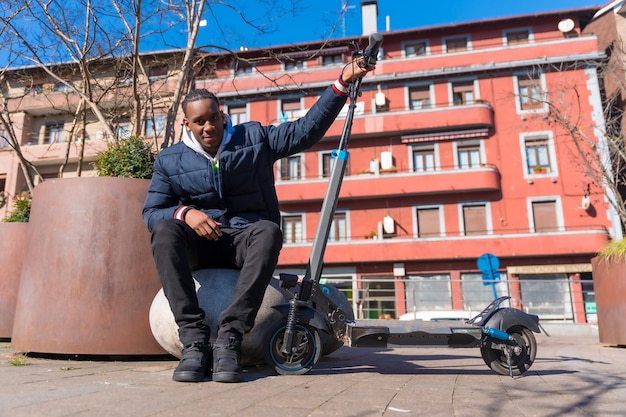 Portrait d'un homme noir ethnique faisant du skateboard sur un skateboard électrique dans la nouvelle mobilité de la ville dans un parc