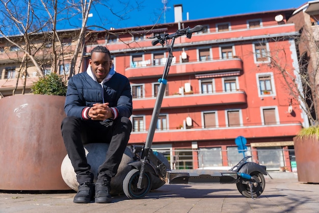 Portrait d'un homme noir ethnique faisant du skateboard sur un skateboard électrique dans la nouvelle mobilité de la ville