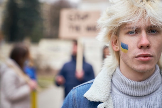 Portrait d'un homme avec de la peinture sur le visage pendant une manifestation