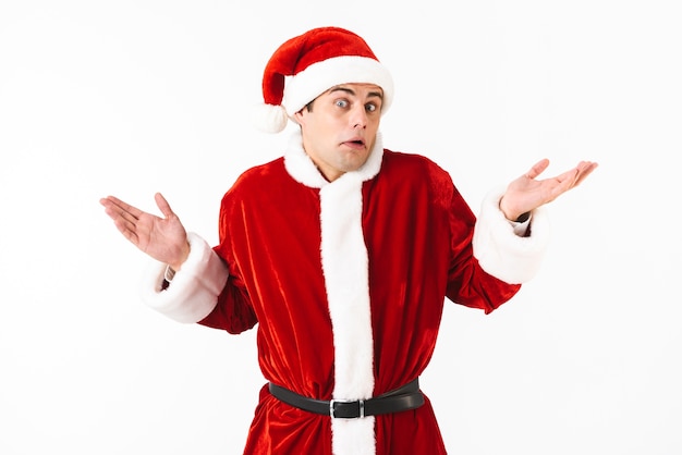 Portrait d'homme perplexe des années 30 en costume de père Noël et chapeau rouge jetant les mains