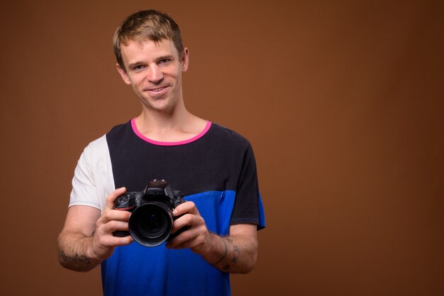 Portrait d'homme photographe à l'aide d'un appareil photo reflex numérique en studio