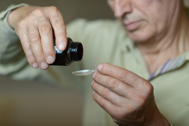 Portrait d'un homme plus âgé prenant un médicament