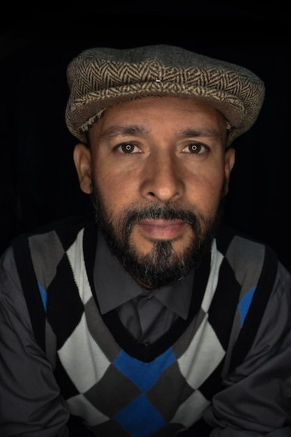 Portrait d'un homme portant une casquette sur un fond noir