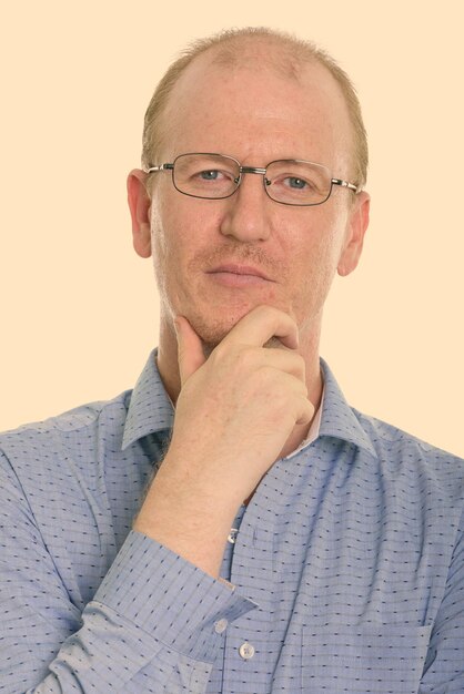 Photo portrait d'un homme portant des lunettes sur un fond gris