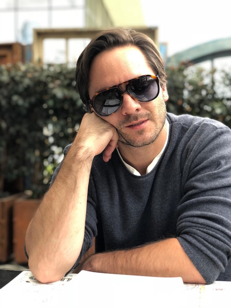 Portrait d'un homme portant des lunettes de soleil alors qu'il est assis à table