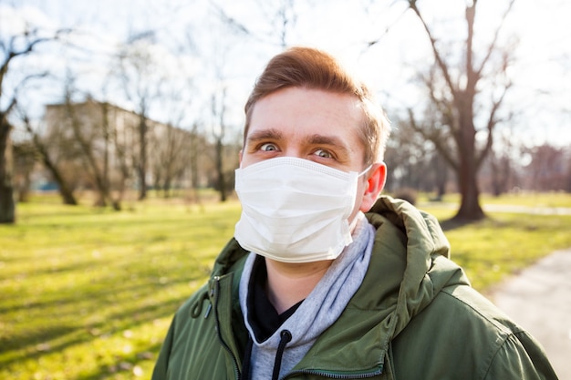 Portrait d'un homme portant un masque médical sur un parc public de la ville