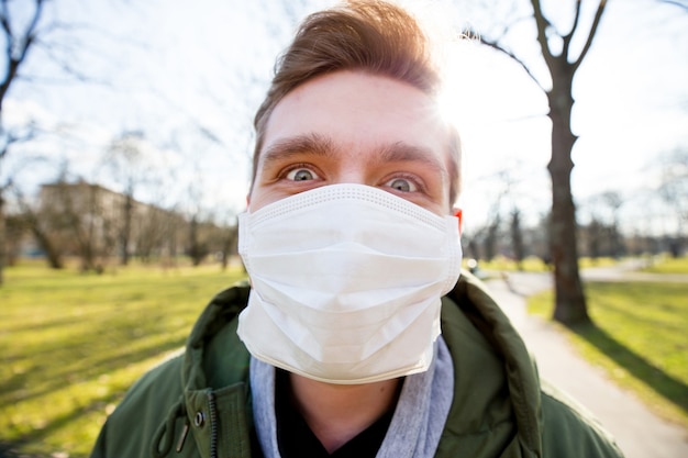 Portrait d'un homme portant un masque médical sur un parc public de la ville