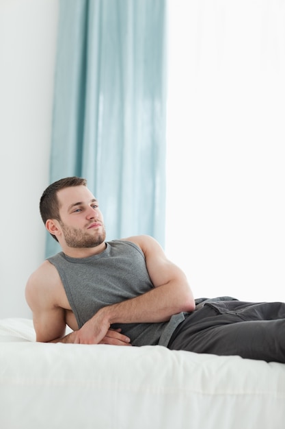 Portrait d&#39;un homme posant sur son lit