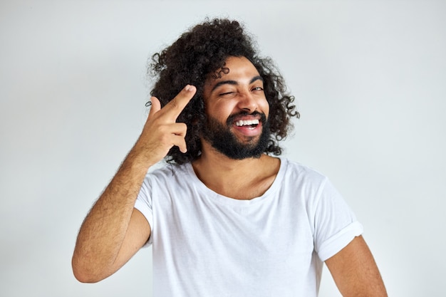 Portrait d'homme positif joyeux d'apparence arabe à la voiture en riant, il écoute une blague